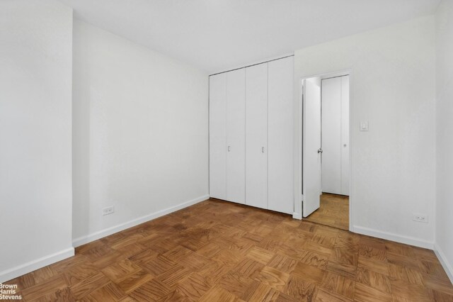 unfurnished bedroom with a closet and light parquet floors