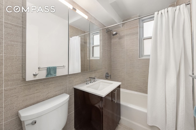 full bath with tile walls, vanity, toilet, and shower / tub combo with curtain