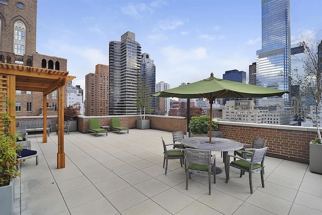 view of patio featuring outdoor dining space, a city view, and a pergola