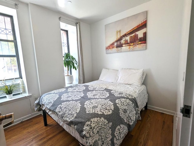 bedroom featuring dark wood finished floors and baseboards