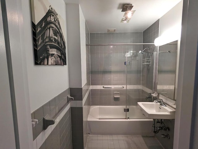 bathroom featuring tile walls, sink, tile patterned floors, and shower / bath combination with glass door