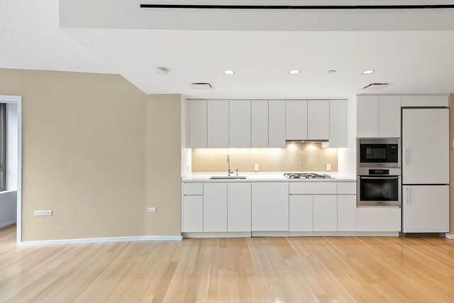 425 W 53rd St Unit 301, New York City, NY 10019 - kitchen with built in appliances, a sink, light wood finished floors, modern cabinets, and white cabinetry