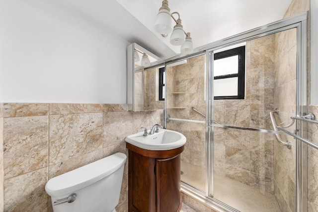 bathroom featuring vanity, a shower with shower door, tile walls, and toilet