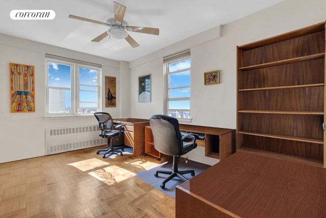 office area featuring ceiling fan, light parquet floors, radiator, and a healthy amount of sunlight