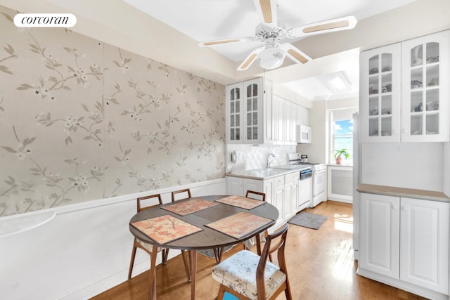 dining space featuring ceiling fan, sink, and light hardwood / wood-style flooring