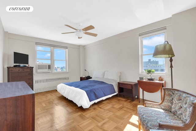 bedroom with ceiling fan, parquet flooring, cooling unit, and radiator