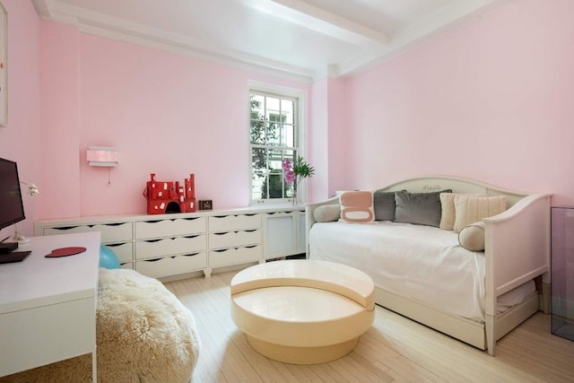 bedroom featuring beam ceiling and light wood-type flooring