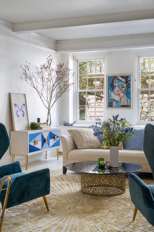 sitting room with ornamental molding and beamed ceiling