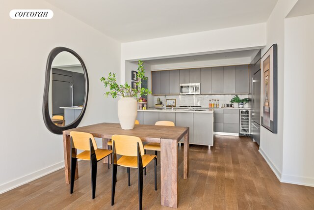 dining space featuring hardwood / wood-style flooring and beverage cooler