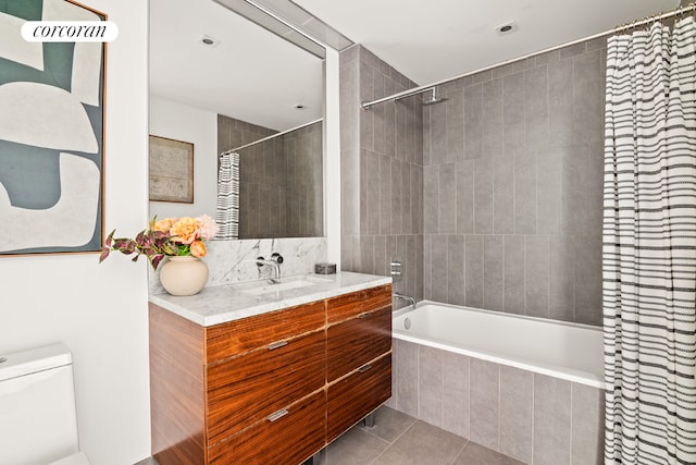 full bathroom with tile patterned flooring, tiled shower / bath combo, vanity, and toilet