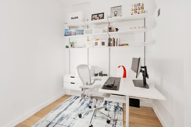 home office with light hardwood / wood-style flooring