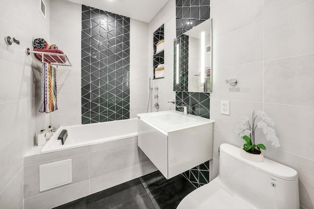 full bathroom with toilet, vanity, tile walls, tile patterned flooring, and tiled shower / bath