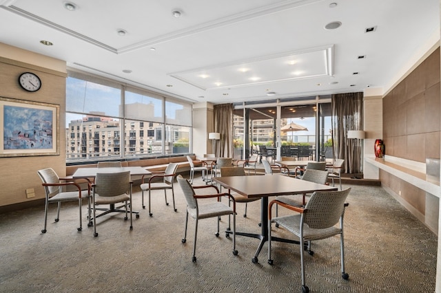 carpeted dining room featuring a raised ceiling