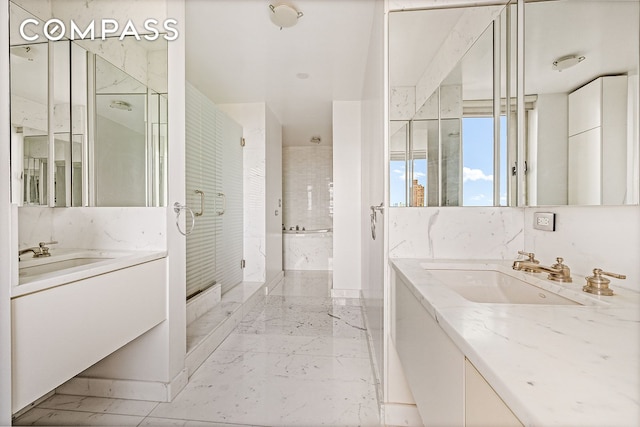 bathroom with a sink, a marble finish shower, two vanities, and marble finish floor