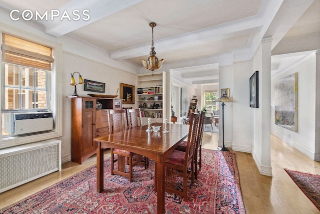 dining area featuring cooling unit, light wood-style flooring, baseboards, radiator, and beamed ceiling