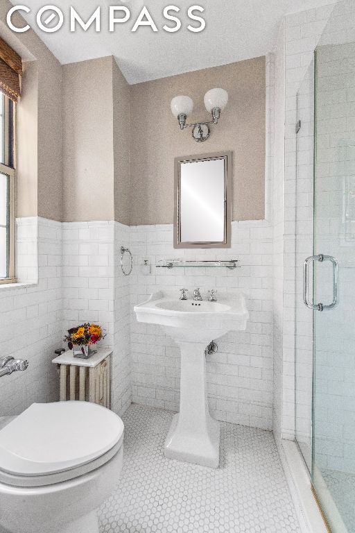 bathroom with tile patterned floors, tile walls, and toilet