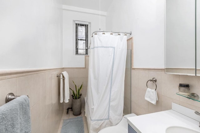 bathroom featuring vanity, toilet, a shower with shower curtain, and tile walls