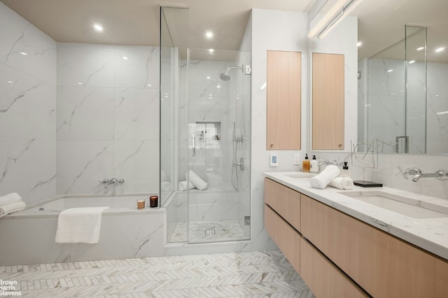 bathroom featuring vanity, independent shower and bath, and tile walls