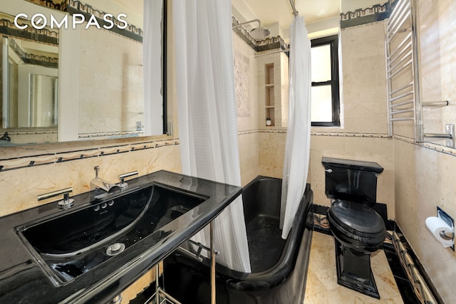 full bath featuring toilet, radiator, tile walls, decorative backsplash, and vanity