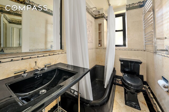 bathroom featuring toilet, a towel warmer, and vanity