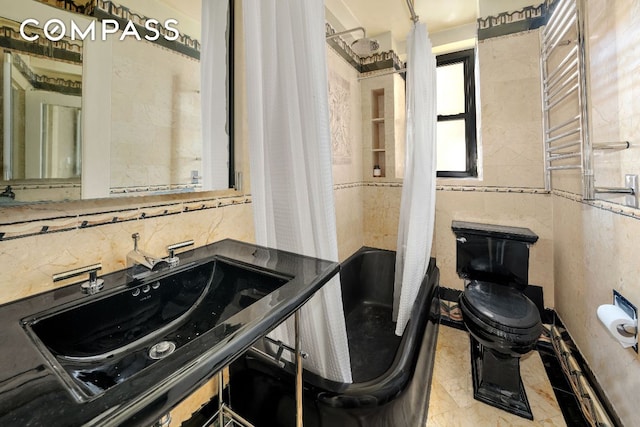 full bathroom featuring sink, shower / bath combo, radiator heating unit, tasteful backsplash, and toilet