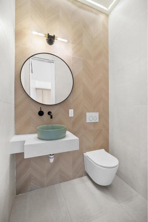 bathroom with tile walls, sink, and toilet