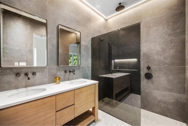 bathroom with tile walls, vanity, backsplash, and walk in shower