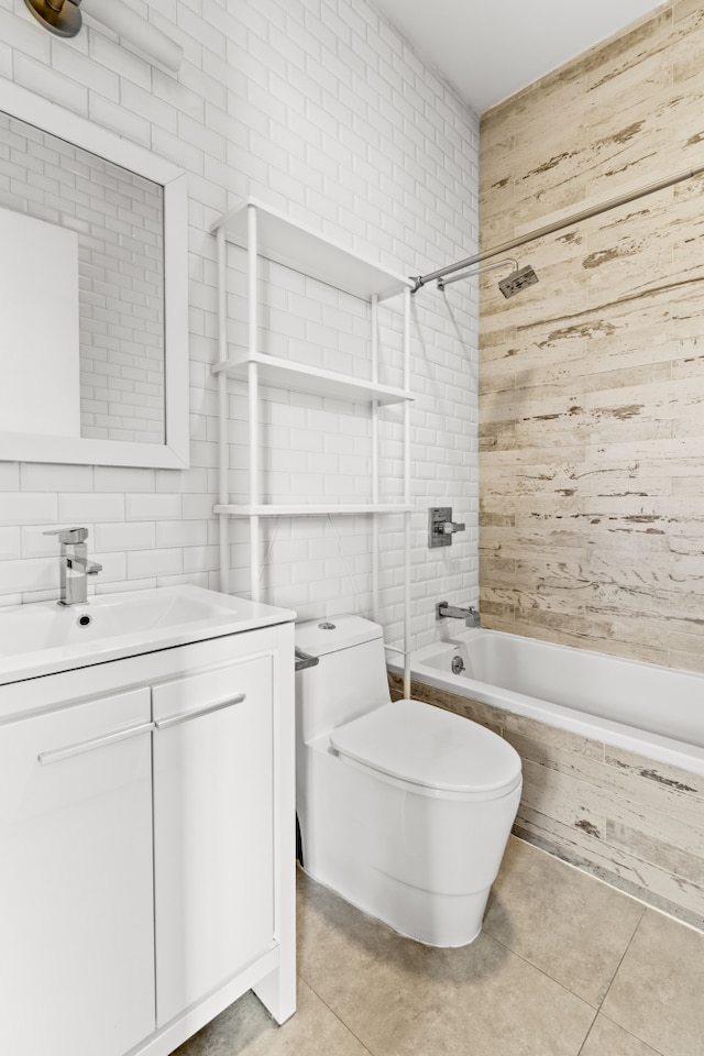 bathroom with toilet, tiled shower / bath combo, tile walls, tile patterned flooring, and vanity