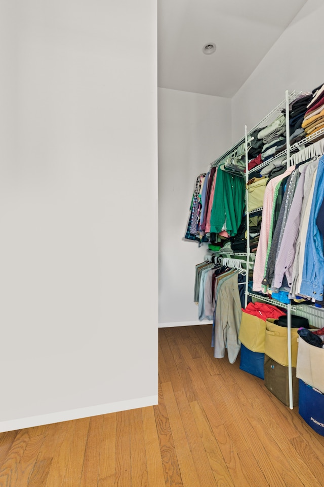 walk in closet with wood finished floors