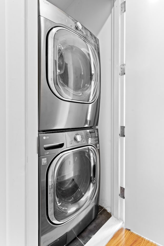 washroom with stacked washer and clothes dryer and laundry area