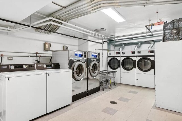 shared laundry area with a garage, light floors, and independent washer and dryer