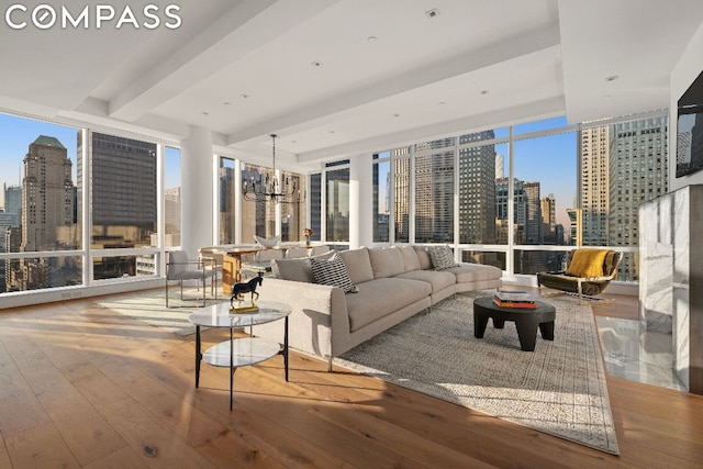 living room with hardwood / wood-style floors, beam ceiling, expansive windows, and a chandelier