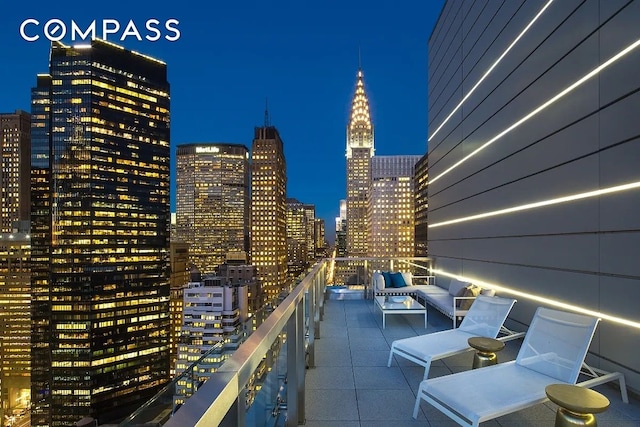 balcony at twilight featuring a view of city lights