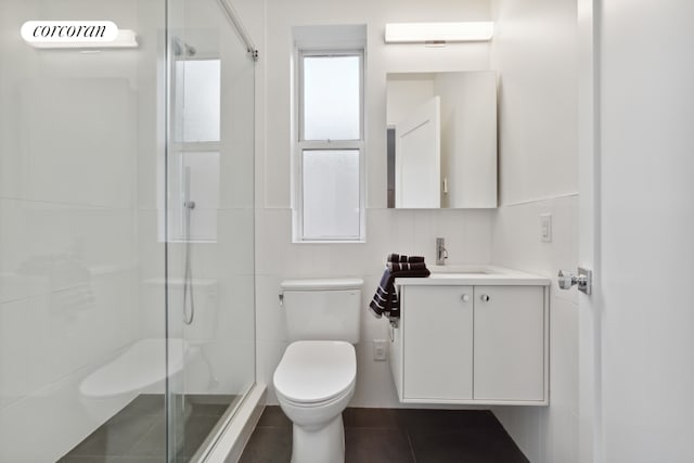 bathroom featuring vanity, a shower with shower door, tile walls, and toilet