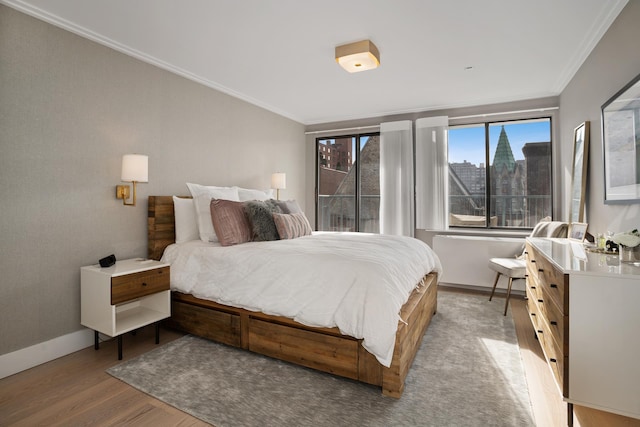 324 W 23rd St Unit 5B, New York City, NY 10011 - bedroom with ornamental molding, baseboards, and wood finished floors