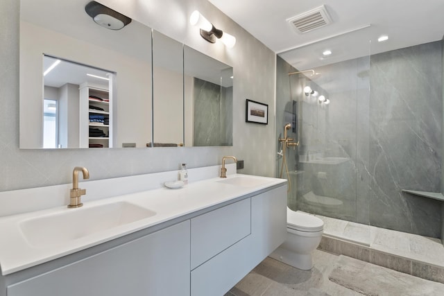 324 W 23rd St Unit 5B, New York City, NY 10011 - bathroom with toilet, a marble finish shower, double vanity, and a walk in closet