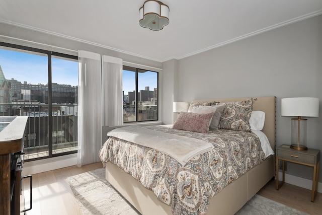 324 W 23rd St Unit 5B, New York City, NY 10011 - bedroom featuring a view of skyline, wood finished floors, ornamental molding, and access to outside
