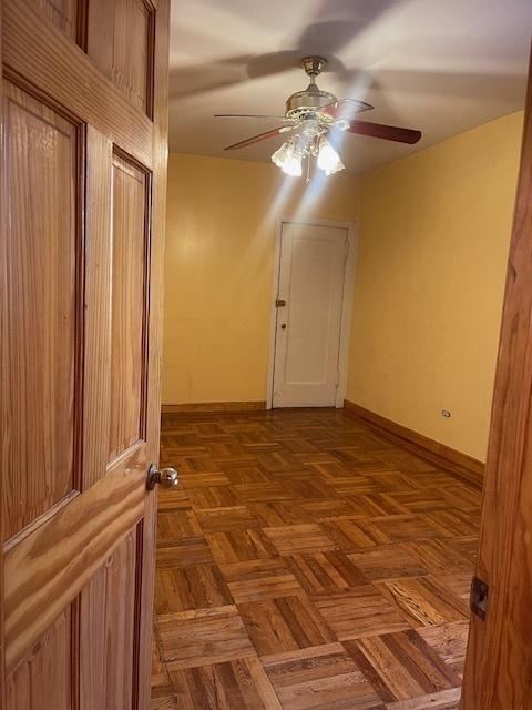 spare room featuring parquet floors and ceiling fan