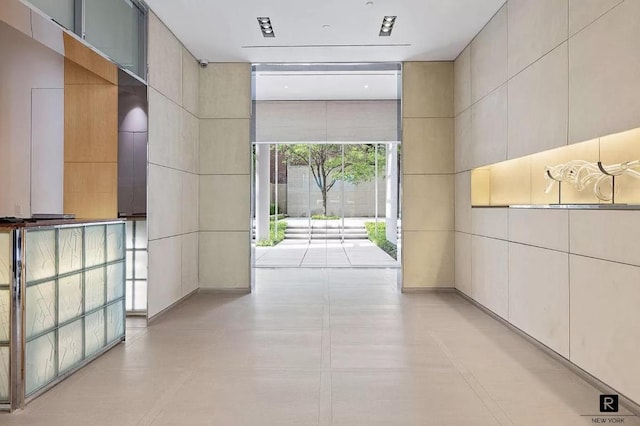 hallway featuring a wall of windows and tile walls