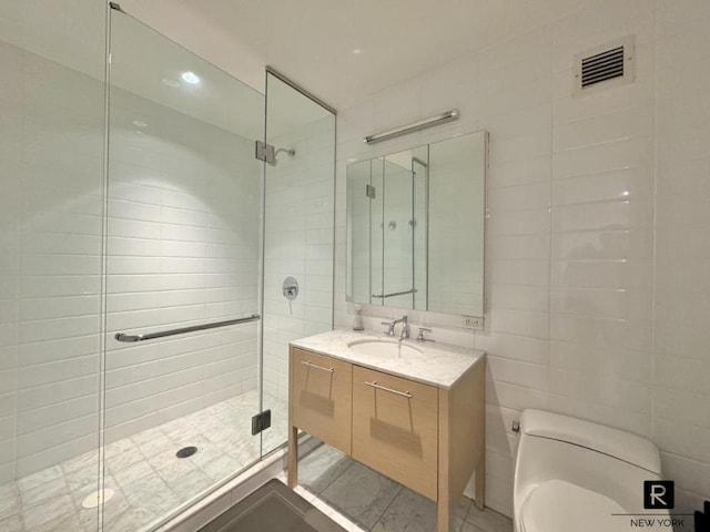 bathroom featuring vanity, toilet, an enclosed shower, and tile walls