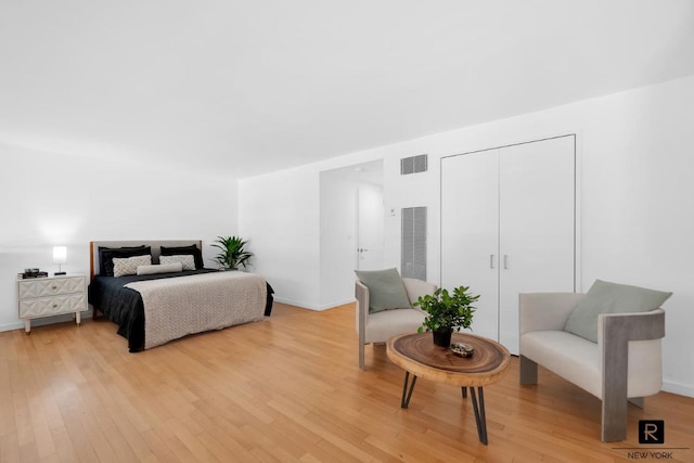 bedroom with light wood-style flooring, a closet, visible vents, and baseboards