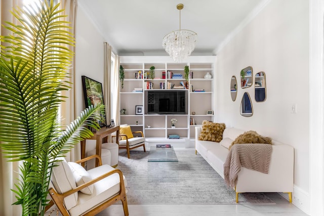 living area featuring ornamental molding, a notable chandelier, and wood finished floors