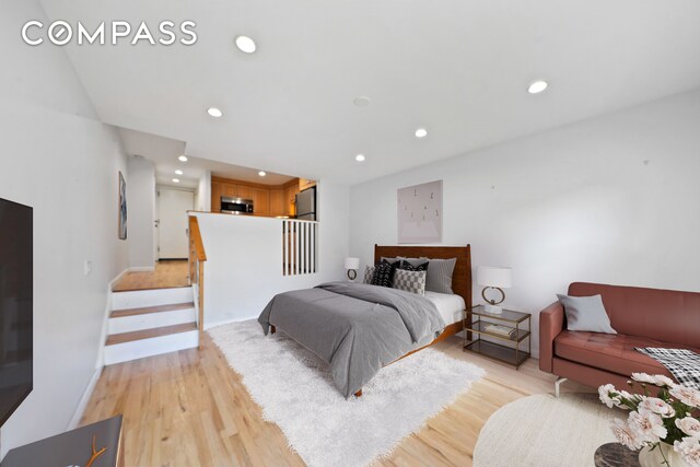 bedroom with baseboards, recessed lighting, freestanding refrigerator, and light wood-style floors