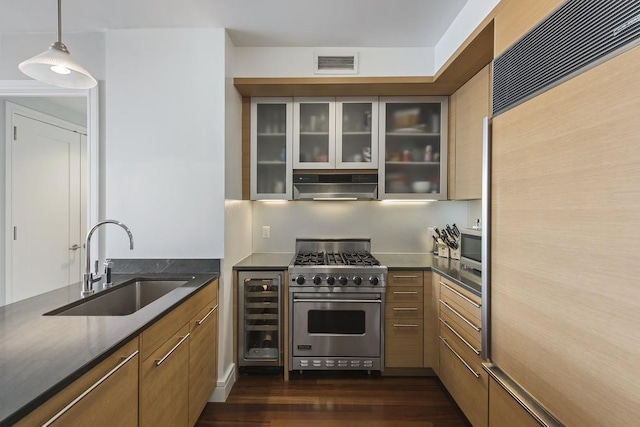 kitchen with wine cooler, sink, high end appliances, pendant lighting, and range hood