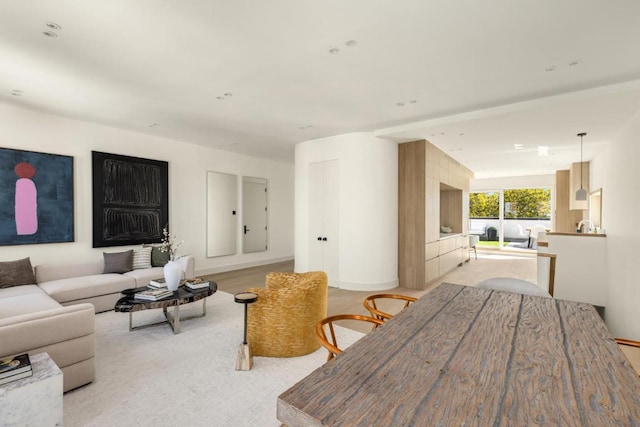 living room featuring beamed ceiling and light wood-type flooring