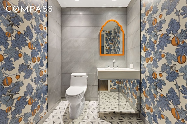 bathroom featuring toilet and tile walls