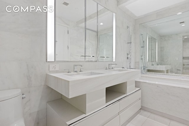 bathroom with tile walls, tile patterned floors, and toilet