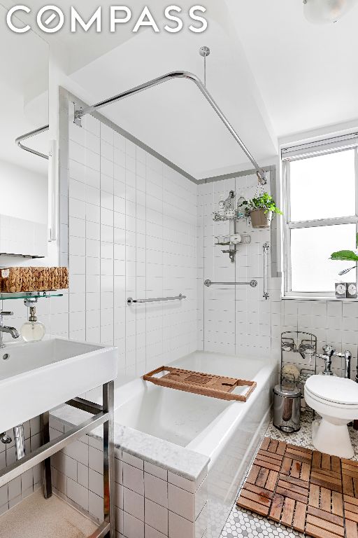 bathroom featuring toilet and tile walls