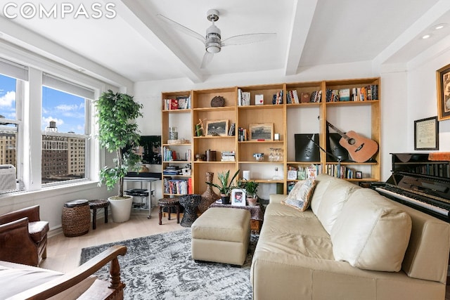 living room featuring ceiling fan, light hardwood / wood-style floors, and beamed ceiling