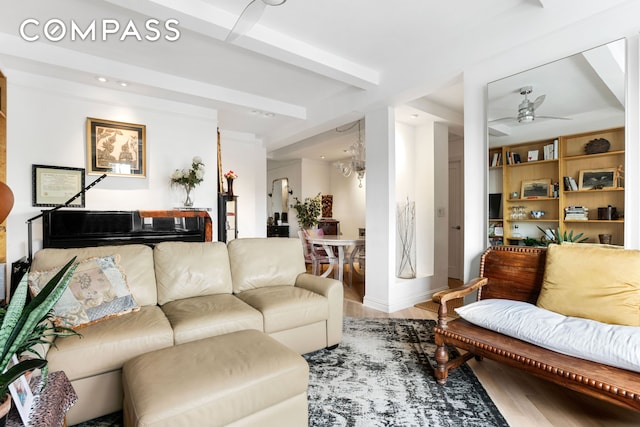 living area with baseboards, a ceiling fan, and wood finished floors